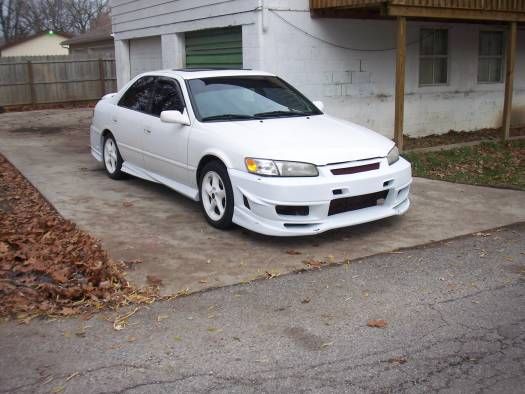 a white car parked in front of a house