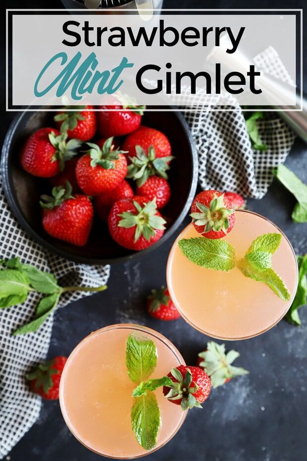 two glasses filled with strawberry mint cocktail next to strawberries