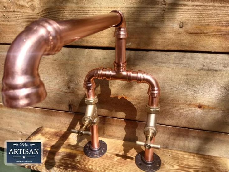 an old fashioned copper faucet on top of a wooden bench