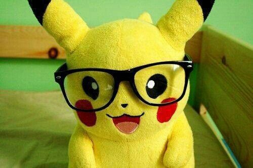 a yellow stuffed animal with glasses on top of it's head sitting on a bed