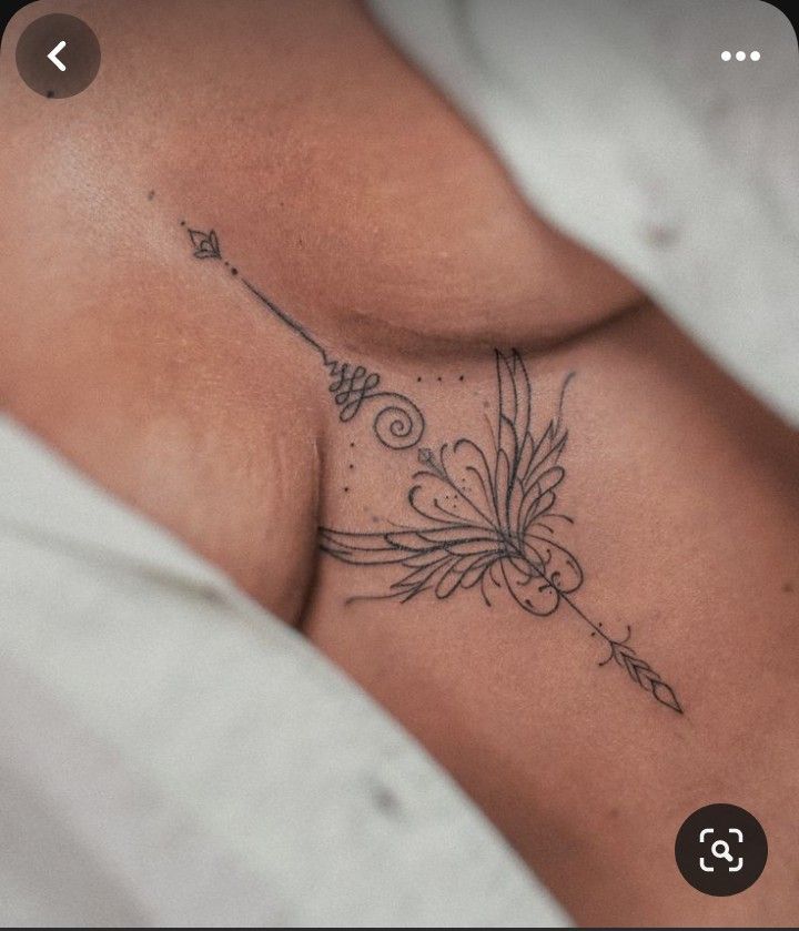 a woman's stomach with an arrow tattoo on it