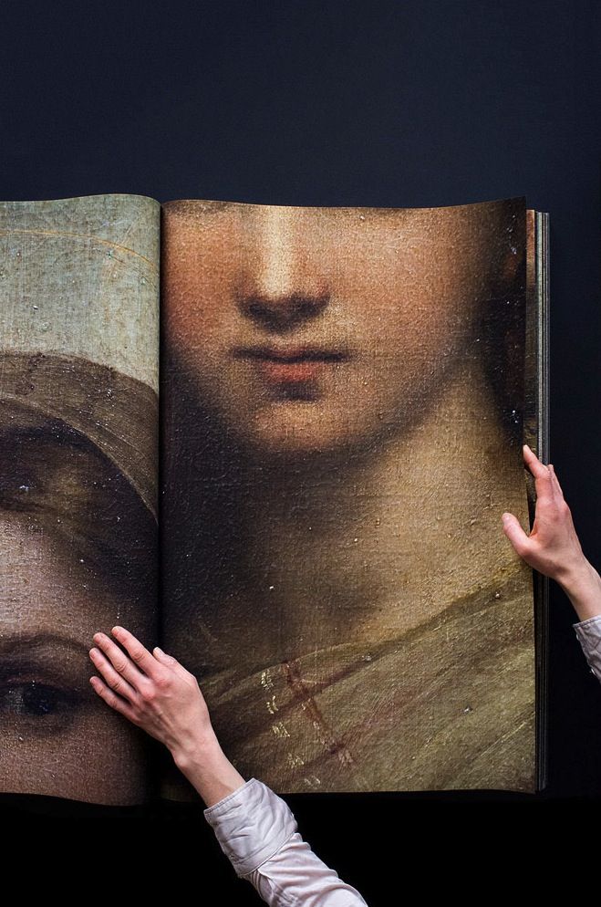 a woman is holding up a book with an image of a woman's face