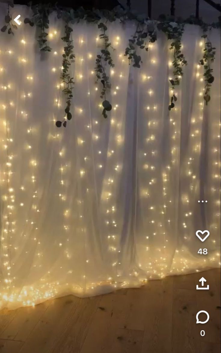 the curtain is decorated with lights and greenery