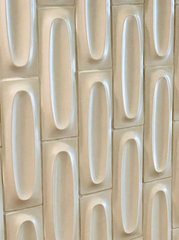 a close up view of a wall made out of different shapes and sizes of white tiles