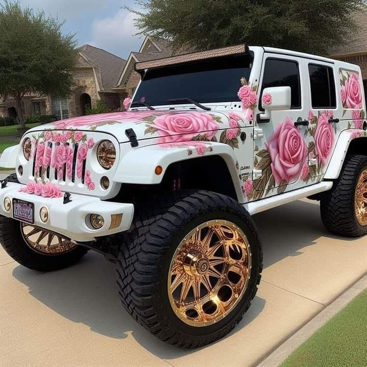 a white jeep with pink roses painted on it's side and gold rims