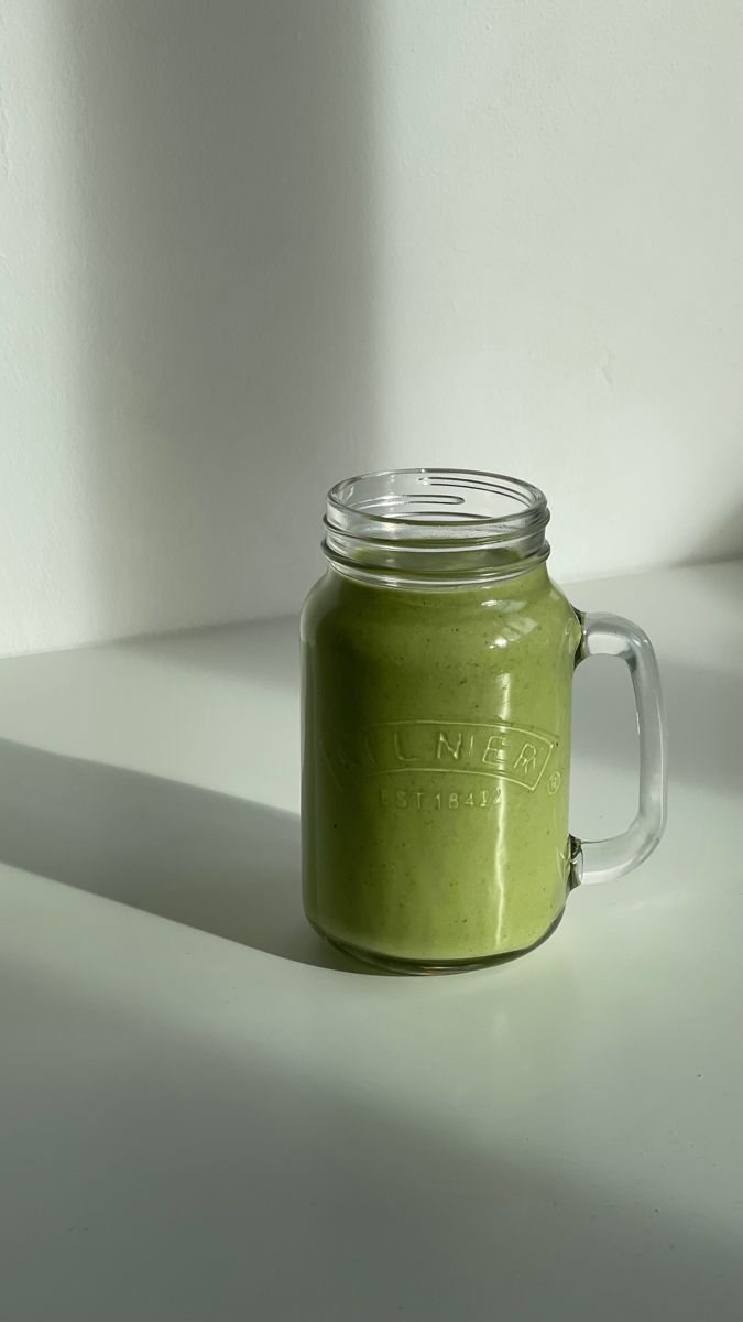 a green mason jar sitting on top of a white counter