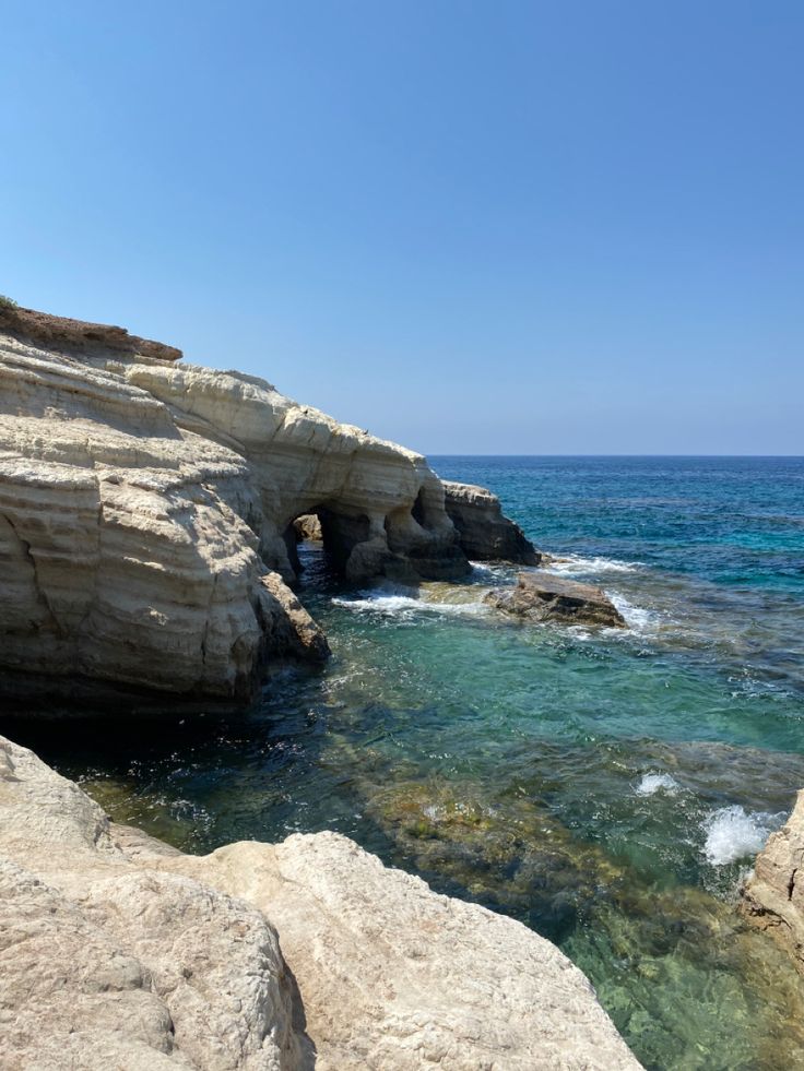 the water is crystal blue and clear at this rocky cliff side area near the beach