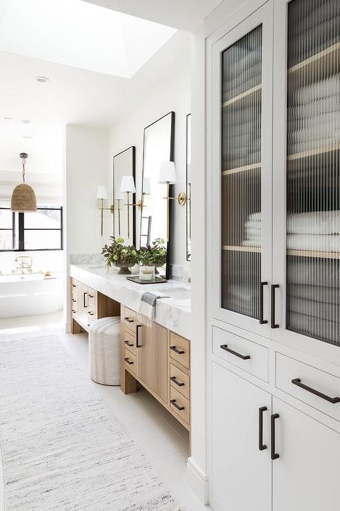 a white bathroom with two sinks and large mirrors