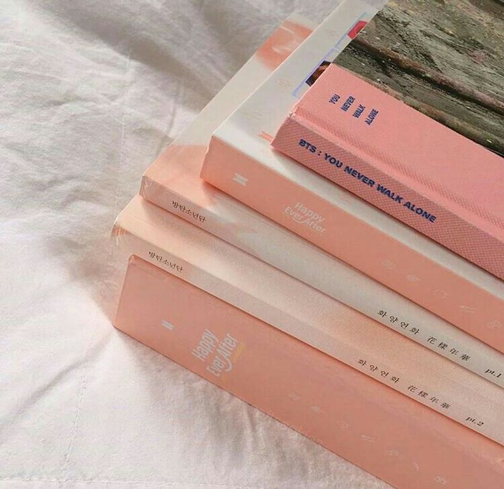 four books stacked on top of each other in pink and white colors with japanese writing