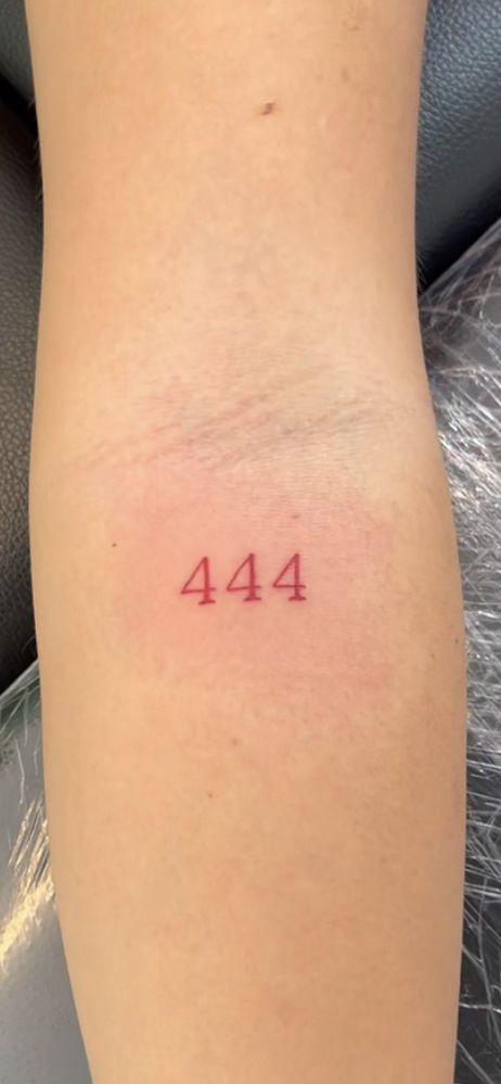 a woman's leg with the number 414 tattooed on her left side arm