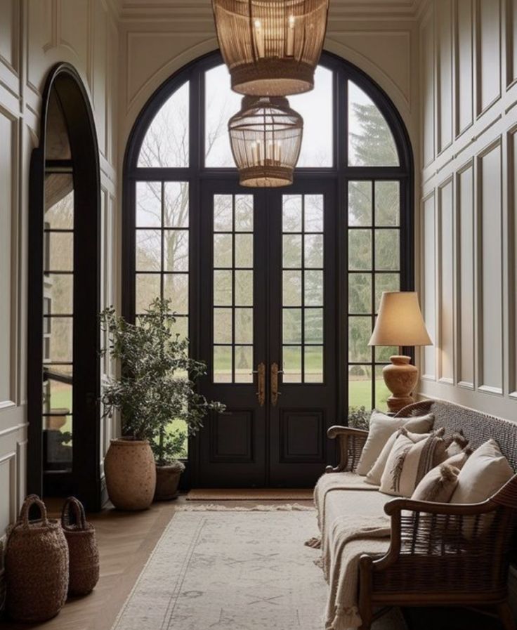 an entryway with large arched windows and lots of natural light coming in from the front door