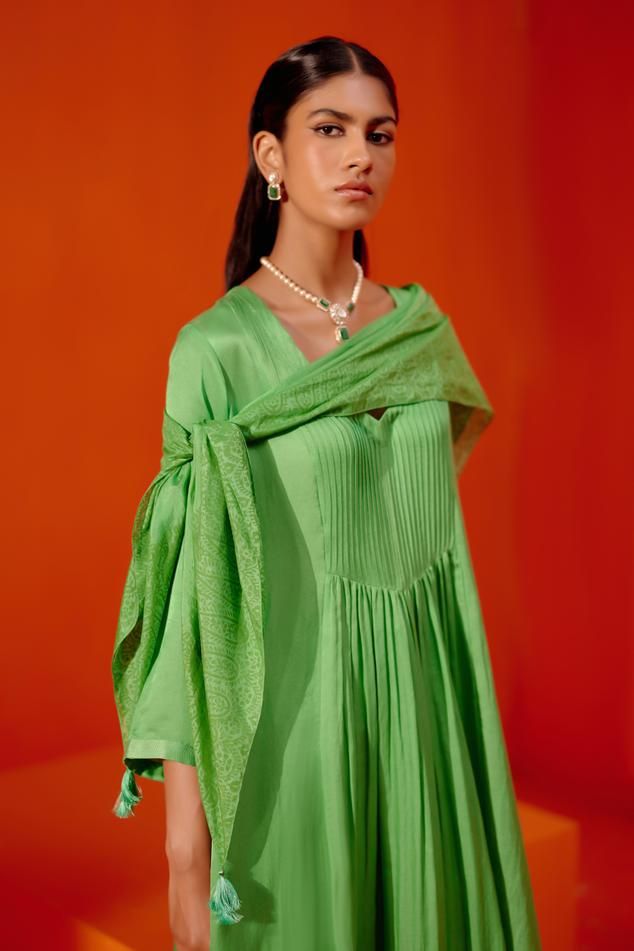 Green kurta features delicate cotton silk satin base with front gathers. Paired with patra work palazzo and a block printed scarf. 
Components: 3
Pattern: Embroiderd
Type Of Work: Patra
Neckline: V Neck
Sleeve Type: Long
Fabric: Silk Chanderi, Tabby Silk and Cotton Silk Satin
Color: Green
Other Details: 
Tassel scarf
Model Height: 5ft 8 inches, wearing size S
Occasion: Puja - Aza Fashions Elegant Silk Anarkali Set With Self Design, Elegant Silk Blouse Piece In Pista Green, Elegant Pista Green Silk Blouse Piece, Elegant Cotton Silk Anarkali Set With Self Design, Elegant Green Palazzo Set With Self Design, Elegant Cotton Blouse Piece For Festive Season, Festive Elegant Cotton Blouse Piece, Spring Anarkali Silk Dupatta, Elegant Summer Dupatta With Pallu