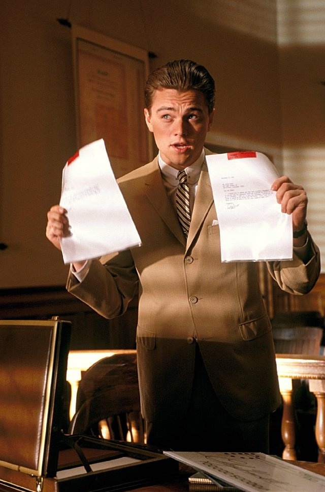 a man in a suit holding two papers