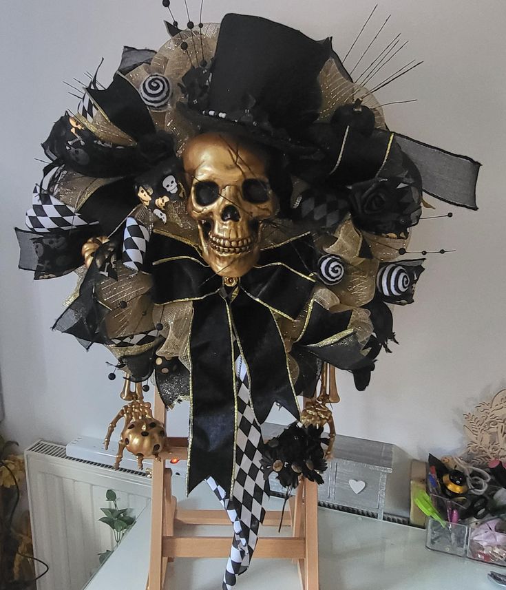 a skeleton wearing a top hat with black and gold decorations