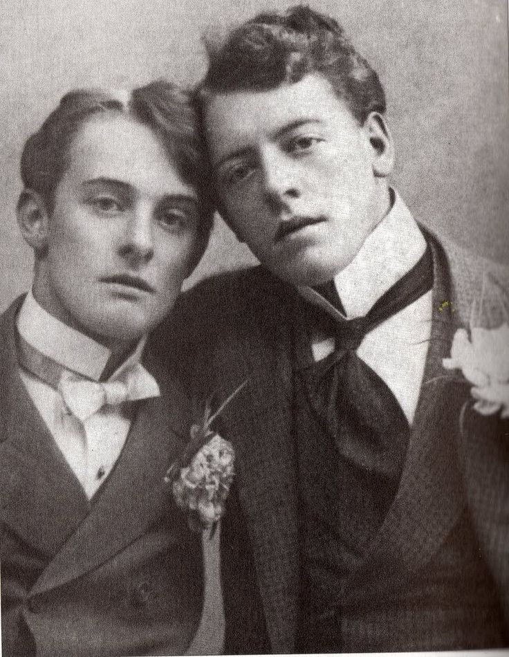 an old photo of two men posing for the camera