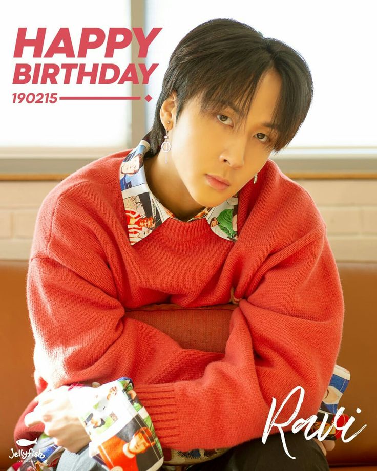 a young man sitting on top of a couch wearing a red sweater