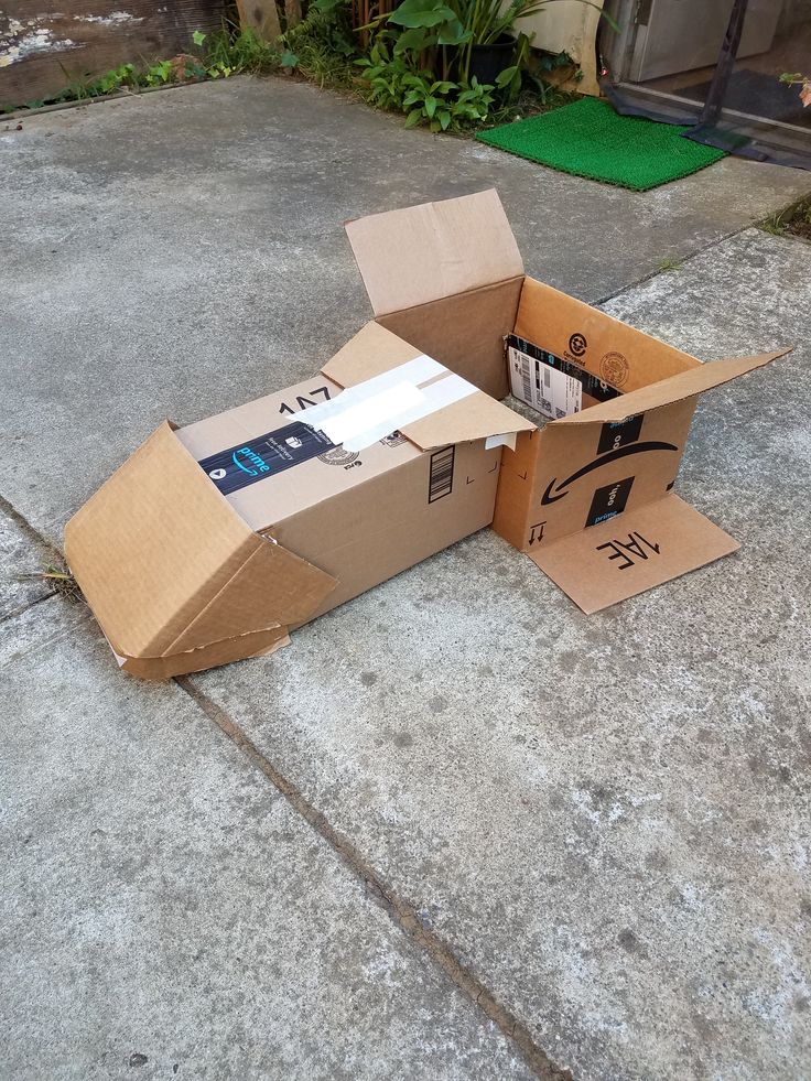 an open cardboard box sitting on the ground