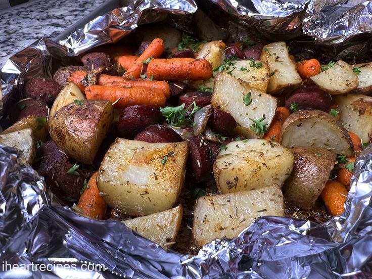 cooked potatoes and carrots in foil with parsley