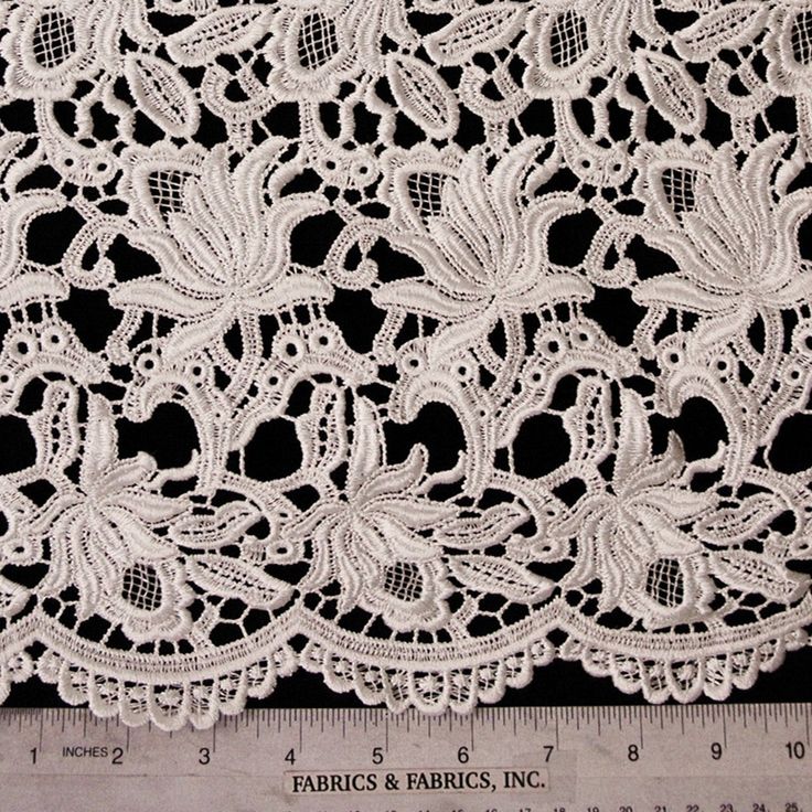 white lace with flowers and leaves on it, as well as a ruler for measuring