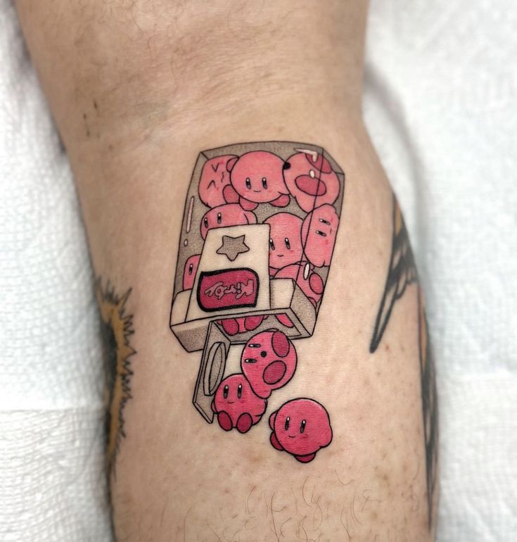 a person with a tattoo on their leg that has pink donuts in the shape of a box