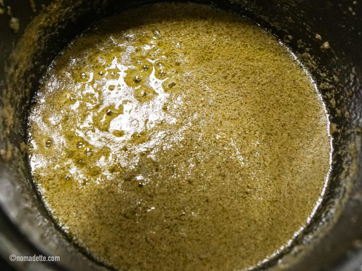 a pot filled with green liquid sitting on top of a stove