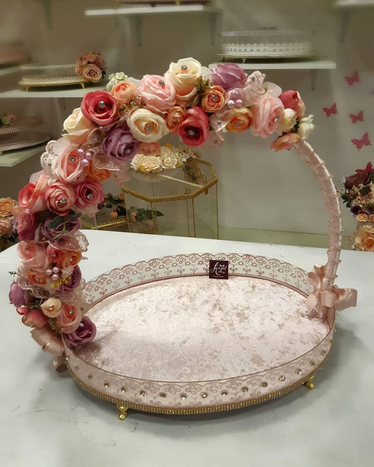 an elaborately decorated cake plate with flowers on the top and bottom, sitting on a table