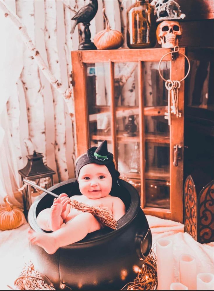 a baby is sitting in a witches hat