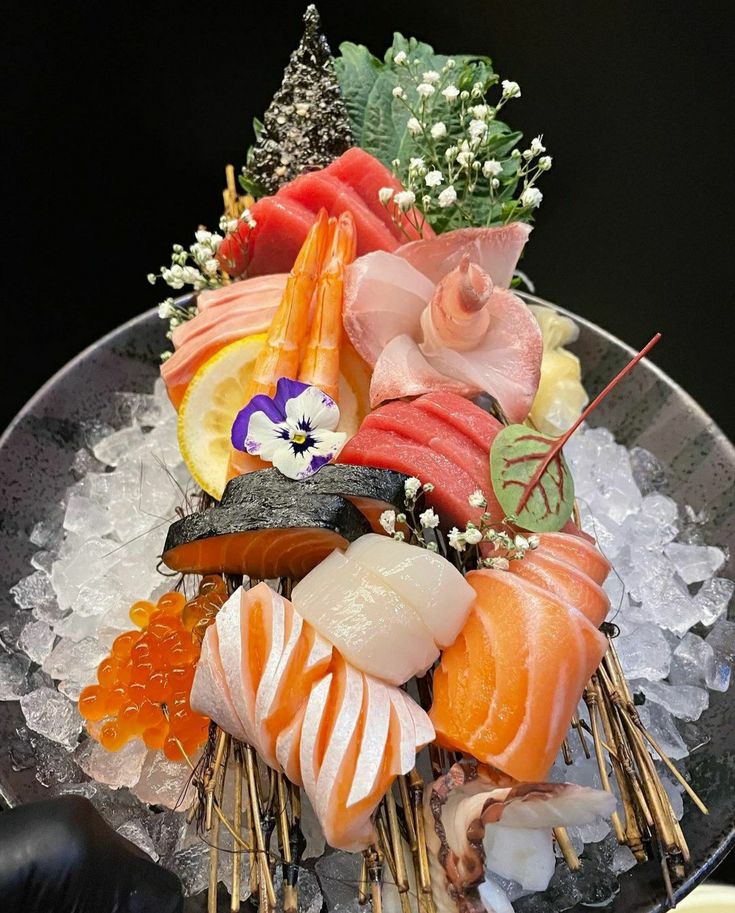 an assortment of sushi on ice in a bowl