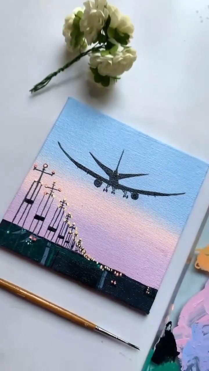 an airplane is flying over the city at sunset, with flowers and paintbrushes next to it