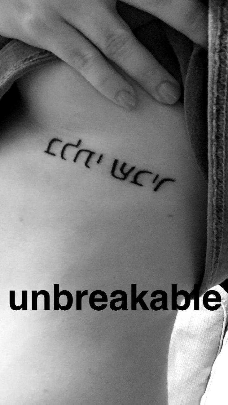 a woman's lower back with the words unbreakable written on her side