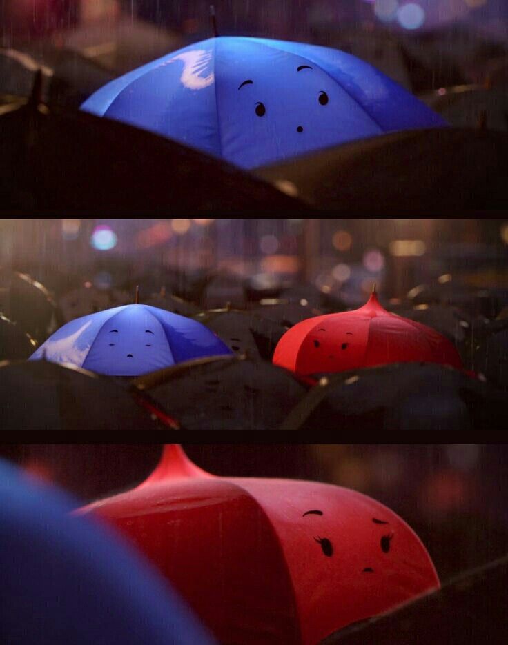 two umbrellas with faces drawn on them in the rain