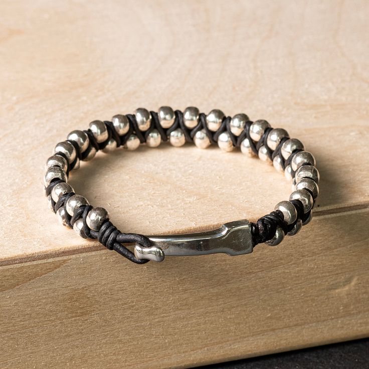 This bracelet features a tightly woven hand braided band with alternating genuine leather and .925 sterling silver handmade beads. The rich texture draws the eye, creating a unique, substantial, and intriguing braided leather bracelet that complements any outfit. Finished with a hook clasp that provides both - convenince and security. Perfect for the minimalist at heart, who likes just the right elevated touch. It can be worn as a stand-alone bracelet or stacked.SHOW YOUR FOREVER LOVE - A piece Modern Adjustable Leather Bracelet With Sterling Silver Clasp, Adjustable Leather Jewelry With Sterling Silver Clasp, Adjustable Leather Jubilee Bracelet For Everyday, Adjustable Jubilee Leather Bracelet For Everyday, Adjustable Silver Leather Bracelet With Sterling Silver Clasp, Modern Silver Leather Bracelet With Sterling Clasp, Hand Wrapped Leather Jewelry With Round Beads, Adjustable Beaded Sterling Silver Bracelet For Everyday, Adjustable Beaded Sterling Silver Bracelet