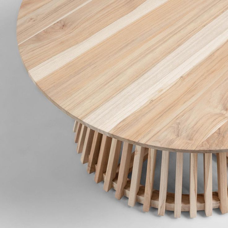 a round wooden table with several sections stacked on it's sides and the top section is made out of thin strips of wood