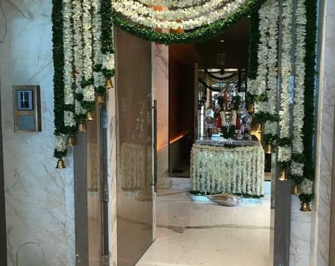 an entrance decorated with white flowers and greenery for a wedding or reception at the hotel