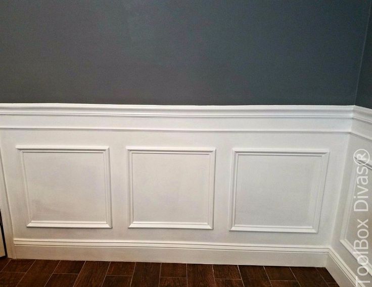 an empty room with white paneling on the walls