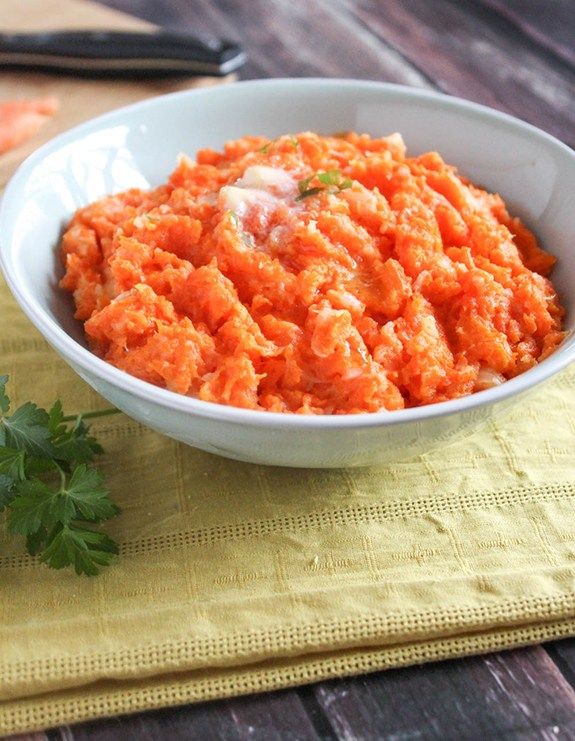 carrot mash with parsley in a white bowl