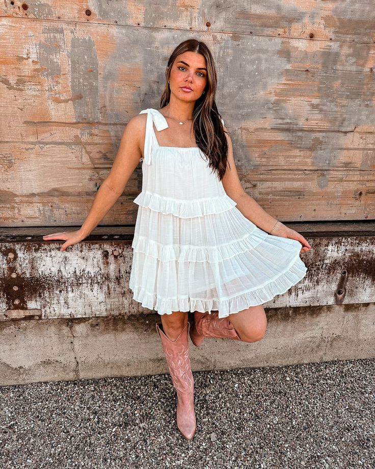 Twirl into spring in style with our darling little white dress! Our Follow Your Happiness Shift Dress features a lightweight material, a low square neckline and upper back with tied shoulder straps, and a relaxed tiered silhouette that falls into a ruffled mid-thigh length hemline! Color: White Tiered Ruffled Detail Mid Length Square Neckline Tied Shoulder Strap Fully Lined No Closures Self: 100% Polyester SIZE + FIT Model is wearing a Small. Her Measurements are: Bust 33" Waist 26" Hip 36" and Square Neck Mini Dress With Ruffles For Day Out, White Tiered Ruffle Dress For Summer, Spring Vacation Tiered Dress With Square Neck, White Flowy Tiered Dress For Summer, Flowy Square Neck Mini Dress With Ruffles, White Square Neck Mini Dress With Bow Straps, White Tiered Dress For Day Out, White Summer Tiered Dress For Day Out, White Tiered Sundress Mini Dress