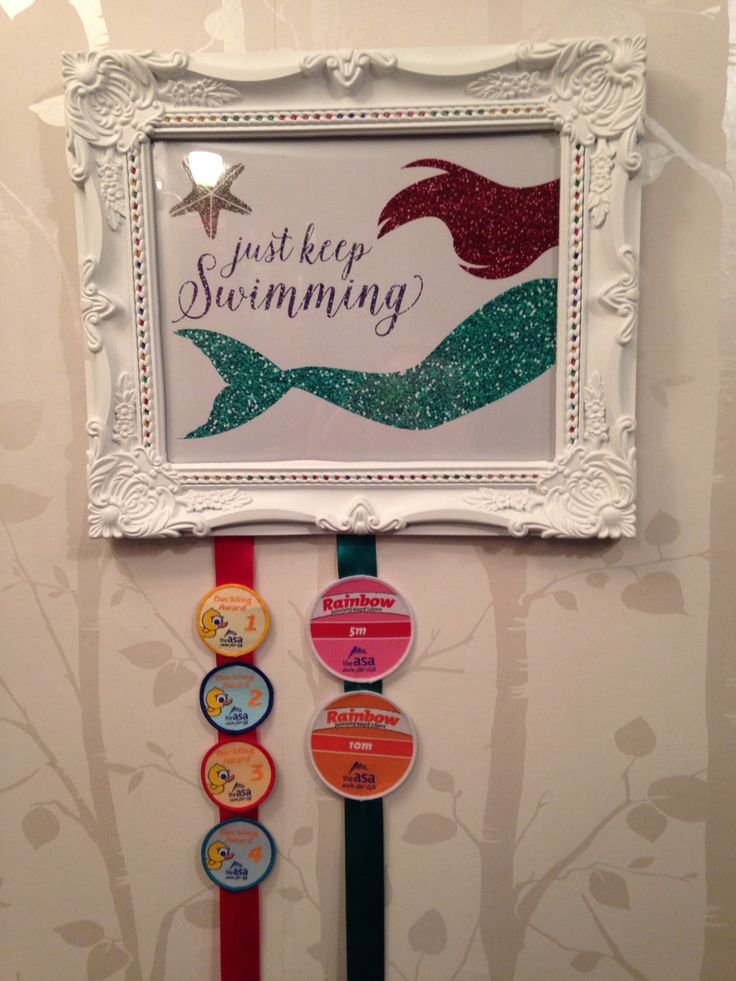 there is a sign that says just keep swimming on the wall next to some magnets