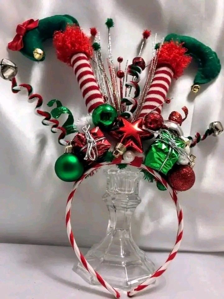 a glass vase filled with candy canes and christmas decorations