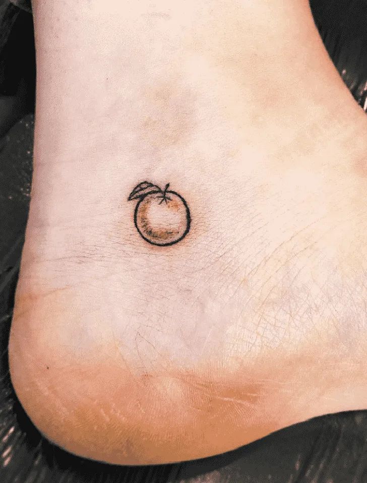 a small apple tattoo on the side of a person's foot with an arrow in it