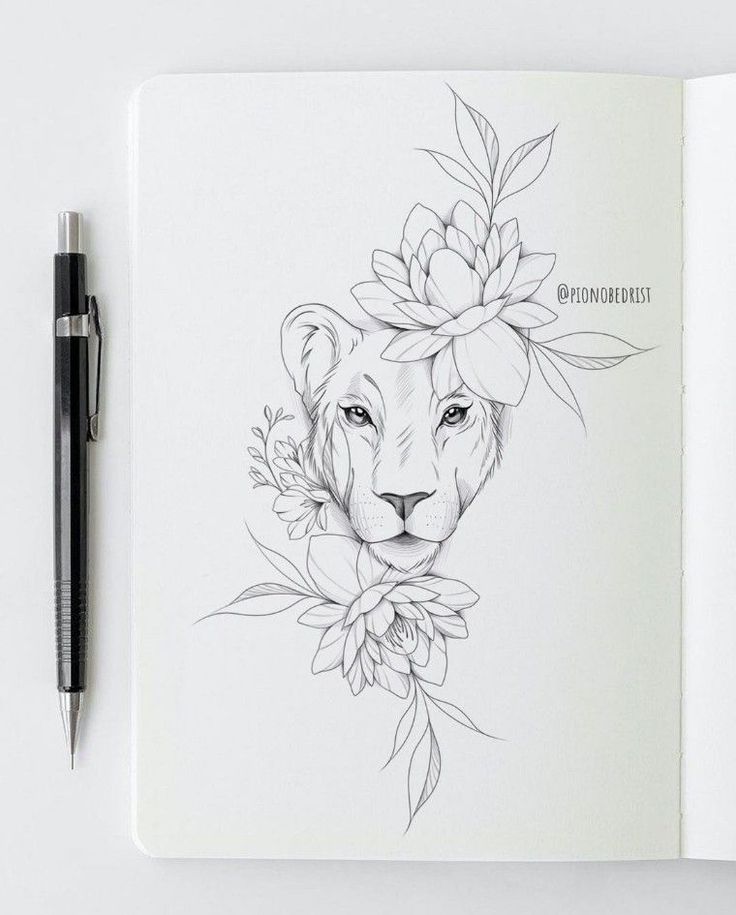 an open notebook with a drawing of a lion and flowers on the cover, next to a pen