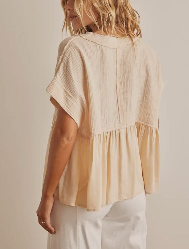 Add a touch of femininity to your wardrobe with our Ruffle Hem Tunic Blouse Top. The delicate ruffle hem adds a playful and romantic touch to any outfit, making you feel confident and stylish. Made with high-quality materials, this top is both comfortable and durable, making it a must-have piece for any fashion-forward woman. The Ruffle Hem Tunic Blouse Top is a perfect delicate top that can also be used as a layering piece. Its ruffle hem adds a feminine and elegant touch, making it ideal for b Feminine V-neck Top With Ruffle Hem, Cream V-neck Tops With Ruffles, Feminine Cotton Blouse For Layering, Chic Blouse With Ruffle Sleeves For Layering, Chic Peplum Blouse With Ruffle Hem, Chic Flowy Cotton Blouse, Beige Feminine Blouse For Layering, Feminine Ruffled Peplum Top, Breezy Cotton Tops With Ruffles