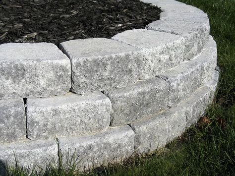 a circular stone garden bed in the grass