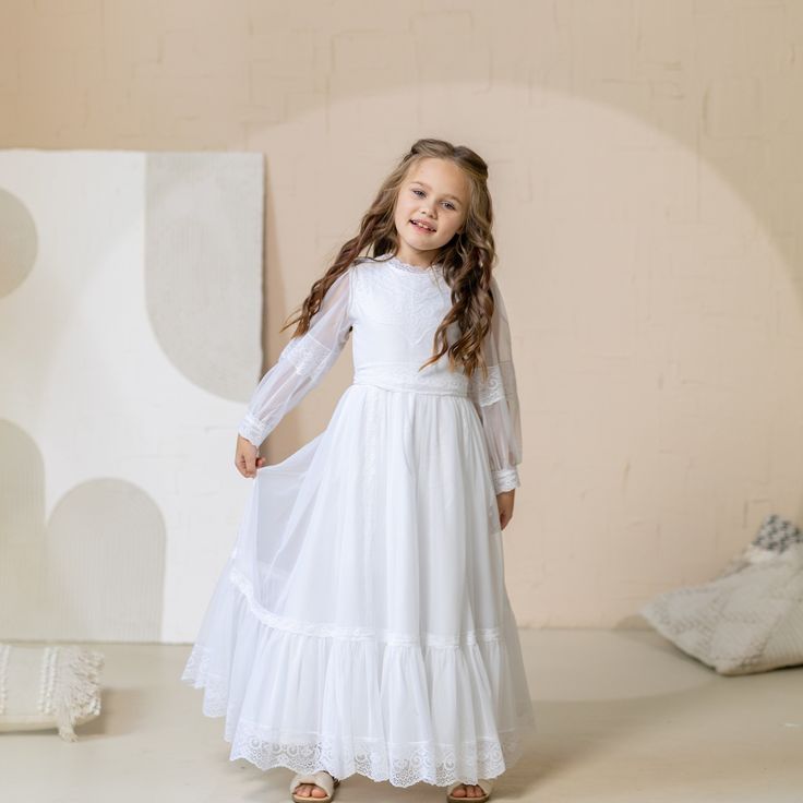 When it comes to selecting the perfect first communion dress, many parents and young girls are looking for something that combines elegance, tradition, and modesty. A holy communion gown with sleeves and a veil can be the ideal choice for this special occasion. The addition of sleeves to a communion dress not only adds a touch of sophistication but also ensures that the young girl feels comfortable throughout the ceremony. Lace communion dresses with sleeves are particularly popular as they exud Fitted First Communion Dress With Lace Sleeves, Baptism Dress With Lace Sleeves For First Communion, Lace First Communion Dress With Lace Sleeves For Confirmation, Fitted Lace First Communion Dress, First Communion White Lace Dress With Long Sleeves, Lace Long Sleeve First Communion Dress, White Lace Long Sleeve First Communion Dress, Fitted First Communion Dress, First Communion Dress With Lace Trim