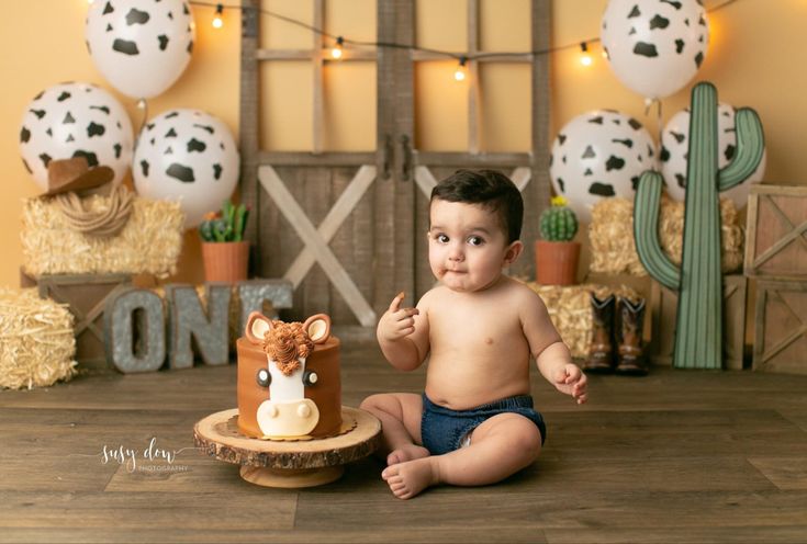 a baby is sitting in front of a cake