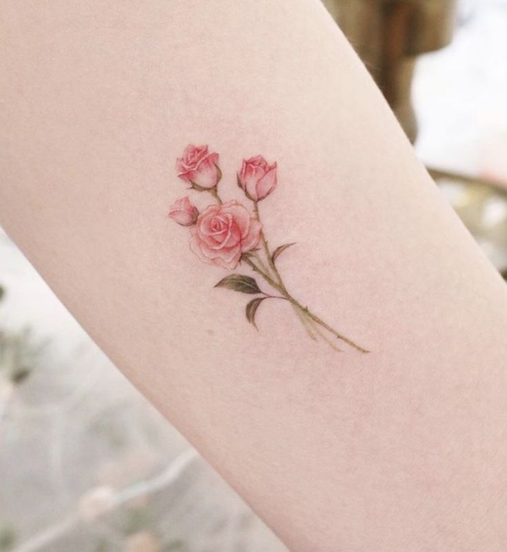 a small pink rose tattoo on the right thigh