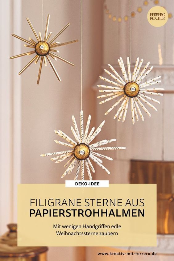 three gold stars hanging from strings in front of a white wall with the words, filigrane sterne aus papierstrotohahmen