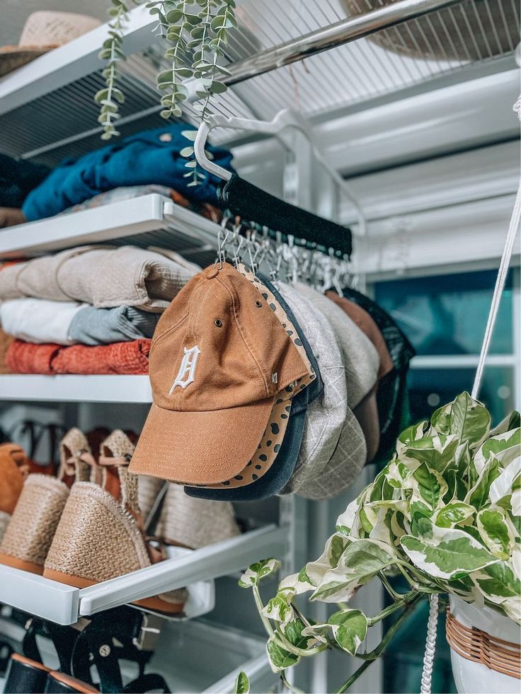 a hat is hanging from a rack in a closet with other hats and purses