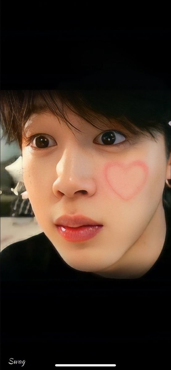 a person with a heart painted on their cheek and nose in the middle of his face