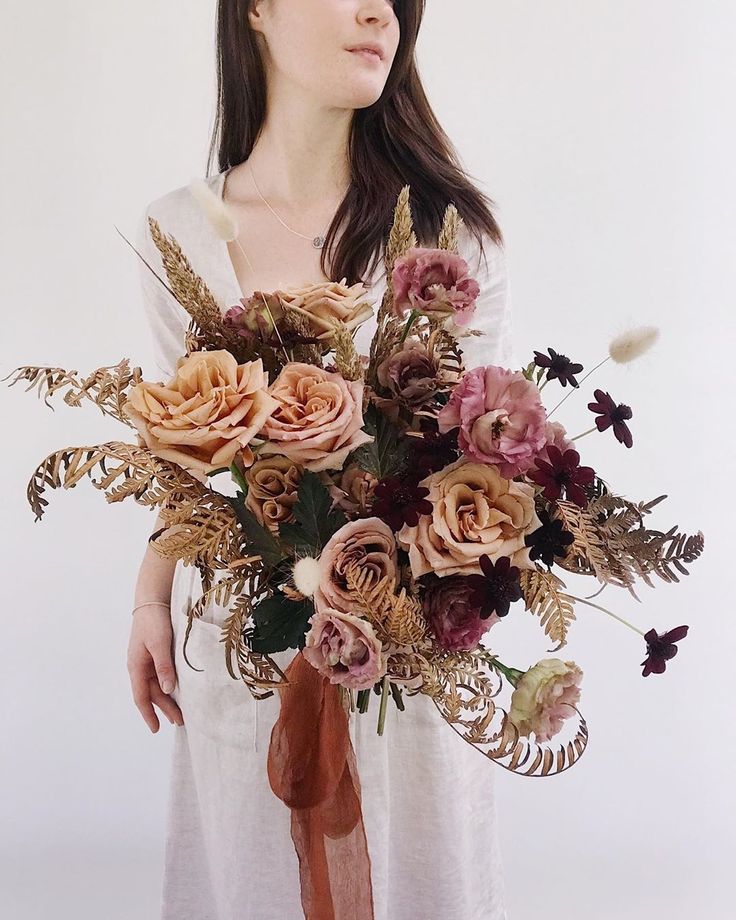 a woman holding a bouquet of flowers in her hands